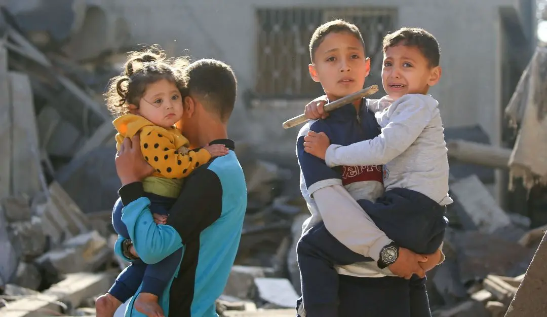 Palestinian children react as they inspect the rubble and debris at the site of Israeli strikes (Photo: AFP)