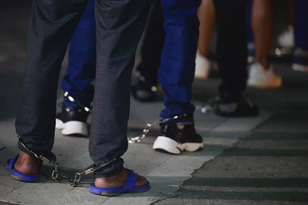 Colombian migrants stand in shackles as they prepare to enter a plane as they are deportated from Marcos A Gelabert de Albrook Airport in Panama City.