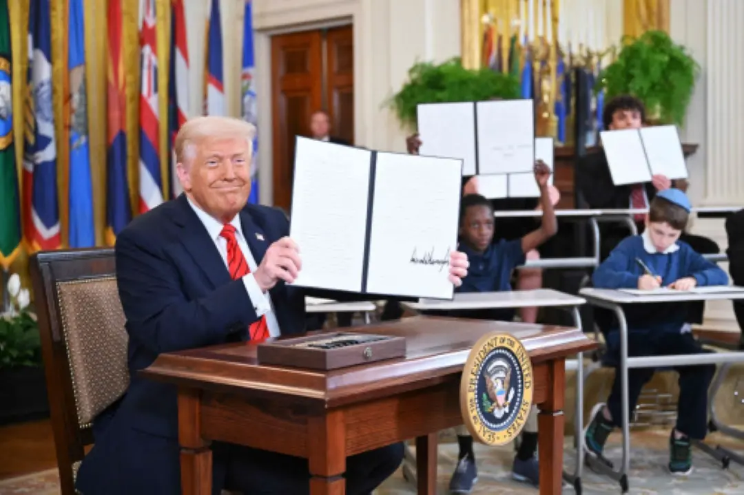 US President Donald Trump holds up an executive order after signing it in the East Room of the White house in Washington, DC | Photo: AFP