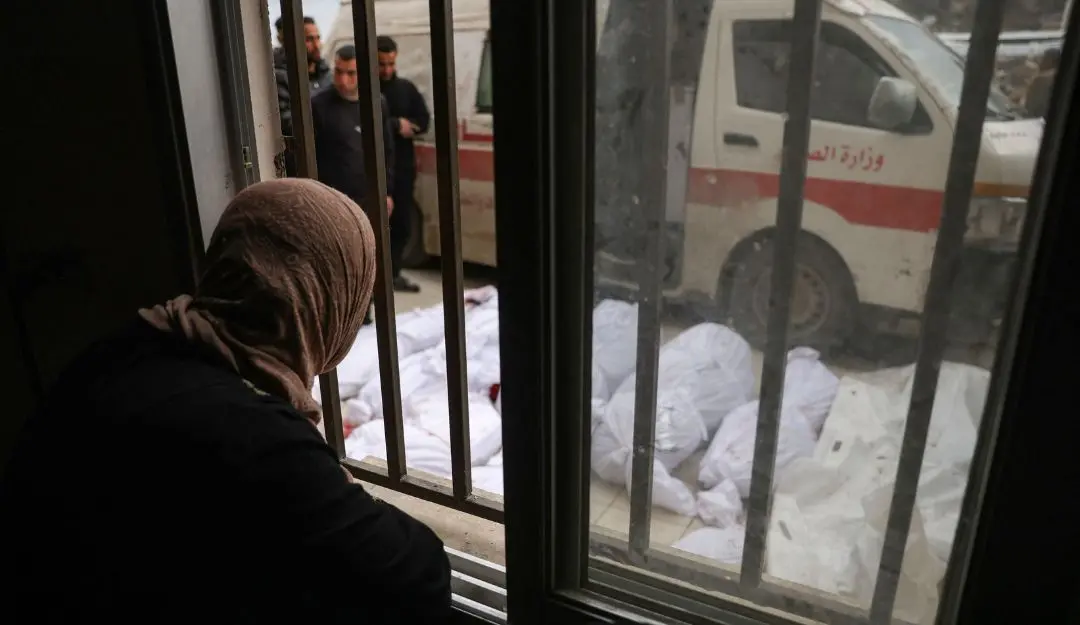 A Palestinian woman stares at bodies of victims of Israeli overnight airstrikes in the northern Gaza Strip (Photo: AFP)