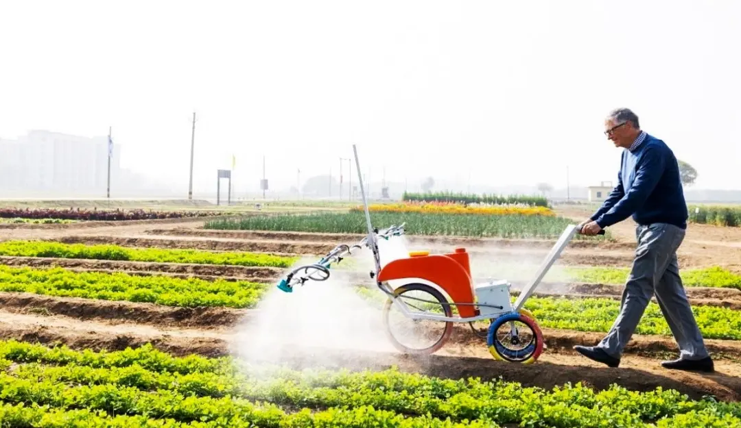 Bill Gates tries hand on the sprayer made by startup in Maharashtra.