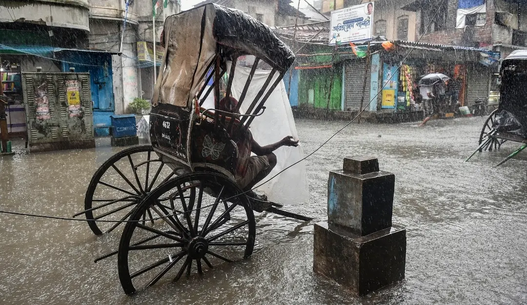 A hand rickshaw puller waits for passengers on a waterlogged road during heavy rain in Kolkata in 2021. | File image: PTI