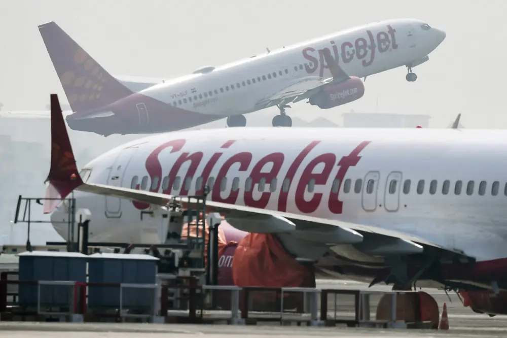 File photo shows a Spicejet aircraft taking off past another parked on the tarmac at Netaji Subhas Chandra Bose International Airport in Kolkata | AFP