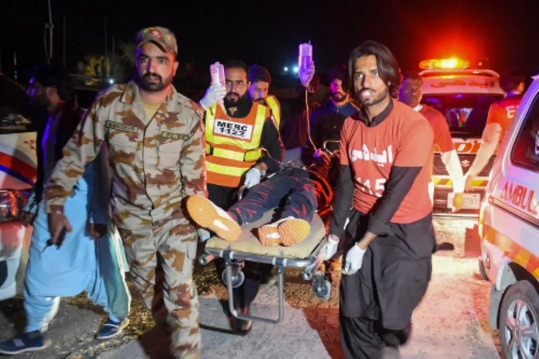 Security personnel and volunteers help to transport an injured train passenger following an operation against armed militants who ambushed the train in the remote mountainous area in Mach, southwestern Balochistan province. | Photo: AFP