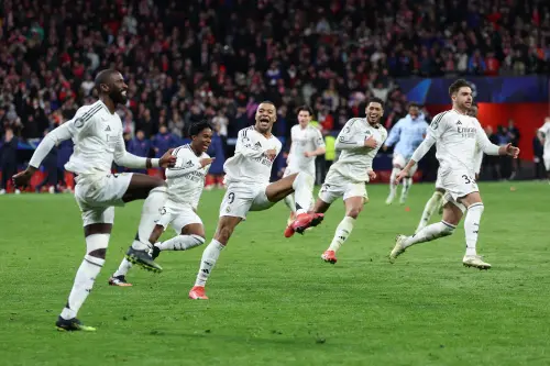 Real Madrid's German defender   Antonio Ruediger, Real Madrid's French forward Kylian Mbappe and teammates celebrate their victory after the UEFA Champions League Round of 16 second leg football match between Club Atletico de Madrid and Real Madrid CF at the Metropolitano stadium in Madrid on March 12, 2025. | Photo: AFP