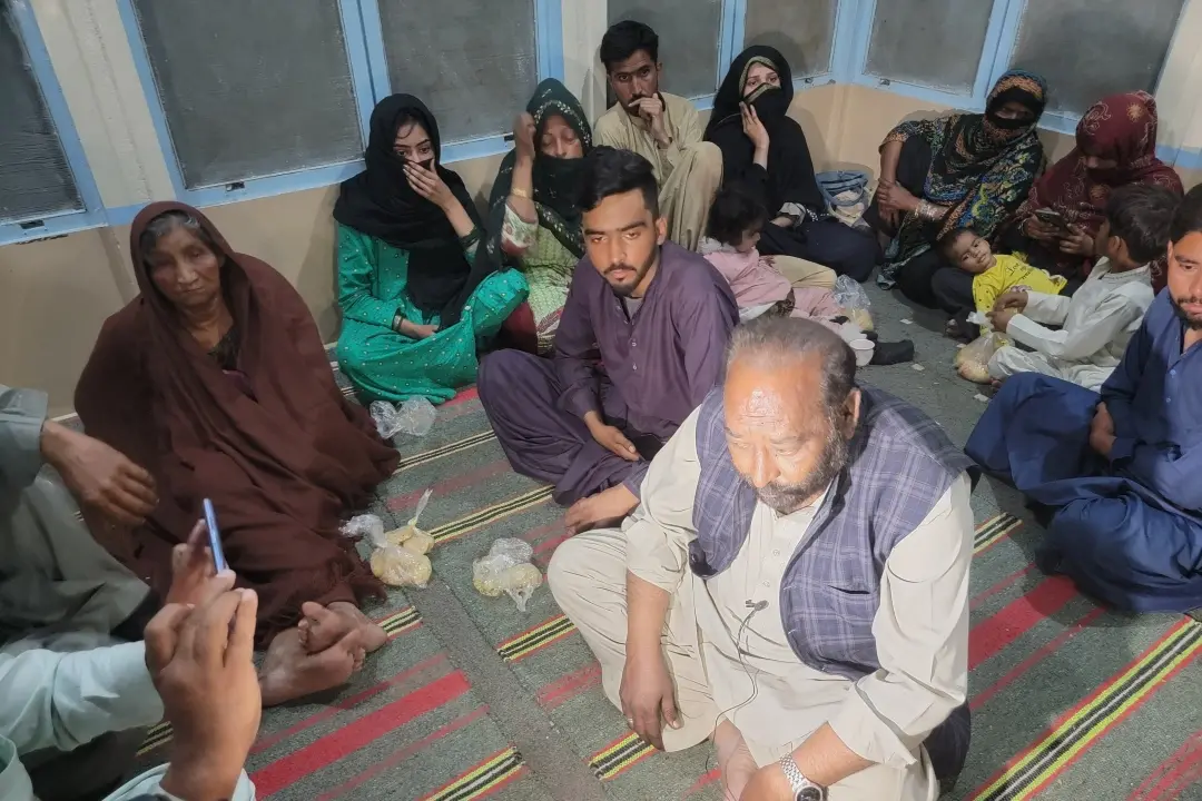 Freed train passengers gather at the Mach railway after being rescued from the train | Photo: AFP