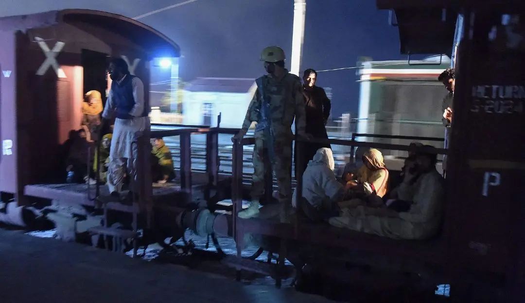 A soldier works to evacuate freed train passengers at the Mach railway station, which has been turned into a makeshift hospital (Photo: AFP)