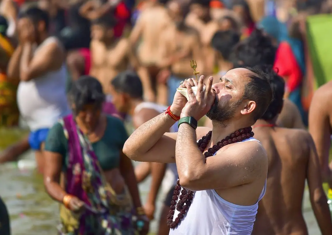 File photo shows a devotee blowing a conch shell while taking a holy dip at the Sangam during the Maha Kumbh Mela 2025