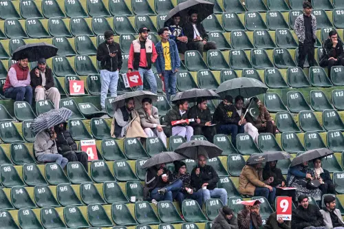 Spectators wait as rain delays the start of the ICC Champions Trophy one-day international (ODI) cricket match between Pakistan and Bangladesh at the Rawalpindi Cricket Stadium in Rawalpindi on February 27, 2025. | Photo:  AFP
