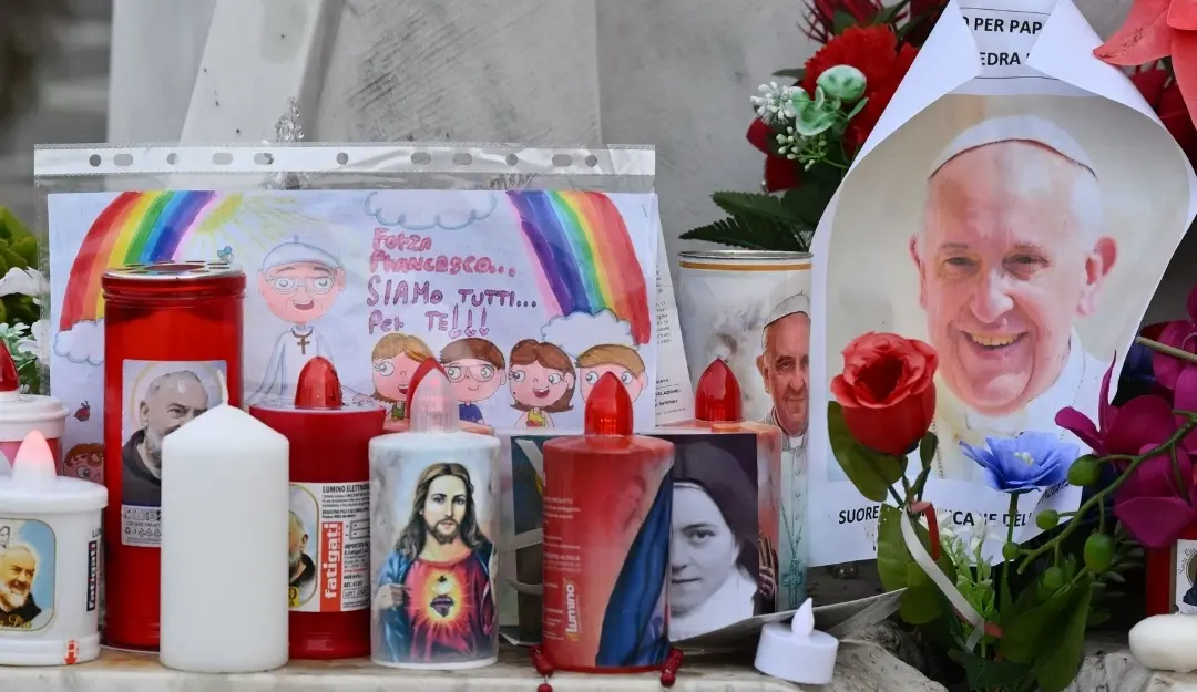 Candles, flowers and a portrait of Pope Francis are laid at the statue of John Paul II outside the Gemelli hospital where Pope Francis is hospitalized, in Rome.