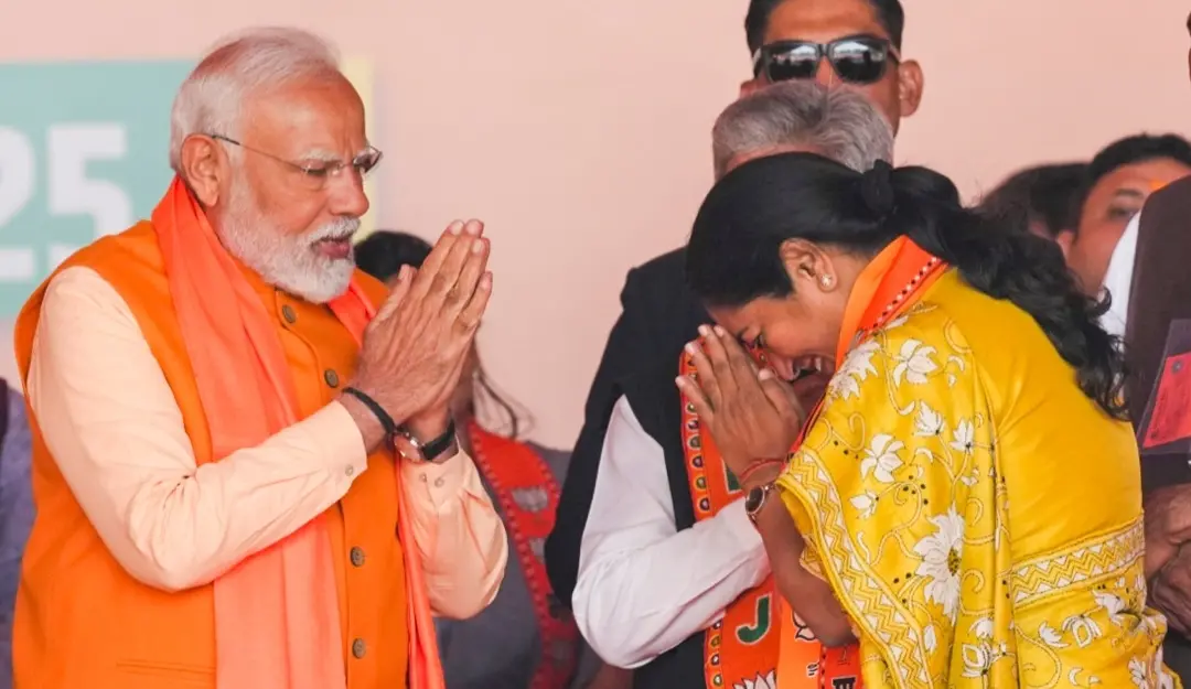 Prime Minister Narendra Modi being greeted by BJP leader Rekha Gupta during a public meeting ahead of the Delhi Assembly elections.