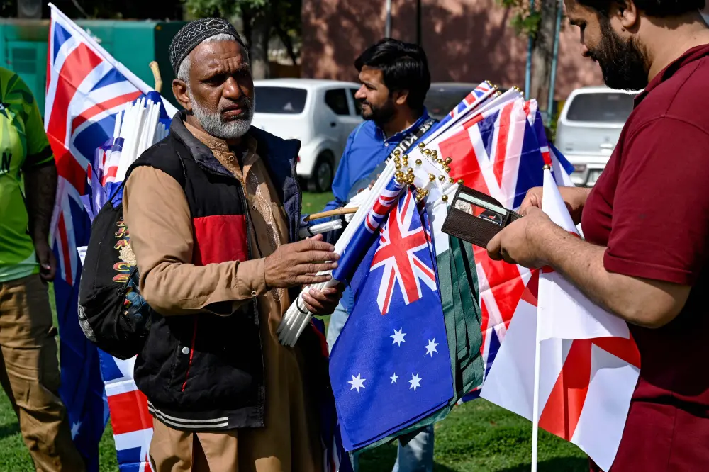 A vendor (L) sells national flags of England, Australia and Pakistan outside the Gaddafi Stadium in Lahore | AFP