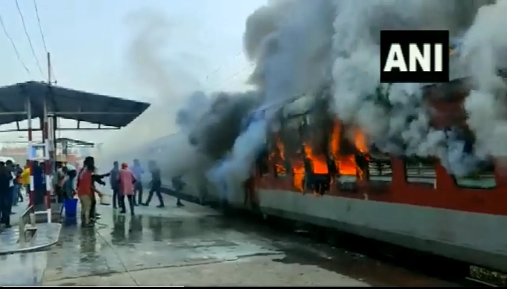People pour water on the train that caught fire | Screenshot from ANI Video