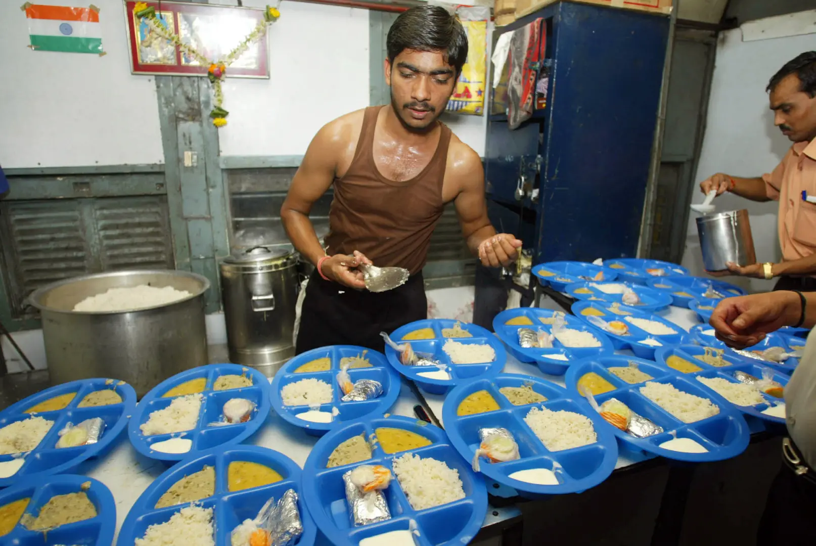 Indian railway workers prepare dinner for the passengers in a pantry car of a train | File photo: AP