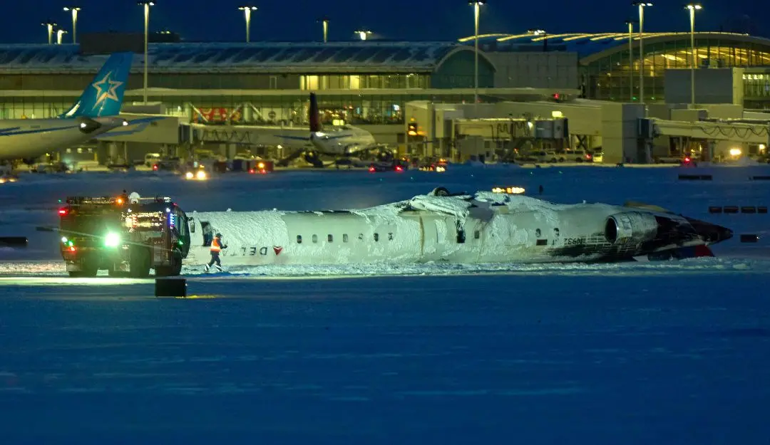 The Delta Airlines plane sits on its roof after crashing upon landing at Toronto Pearson Airport in Toronto, Ontario | Photo: AFP