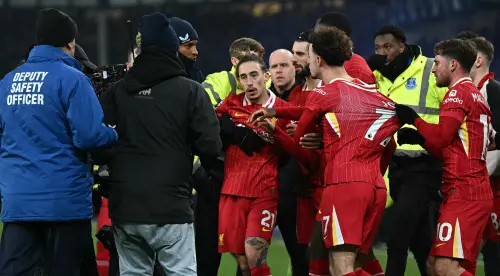 Liverpool's Argentinian midfielder Alexis Mac Allister (R) holds back Liverpool's English midfielder Curtis Jones as he remonstrates with Everton players after the English Premier League football match between Everton and Liverpool at Goodison Park in Liverpool, north west England on February 12, 2025. The match ended in a draw at 2-2. | Photo: AFP