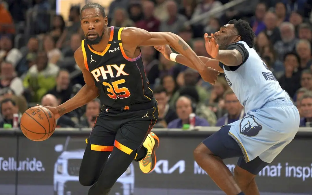 Phoenix Suns forward Kevin Durant (35) drives on Memphis Grizzlies guard Vince Williams Jr. during the first half of an NBA basketball game, Tuesday, Feb. 11, 2025, in Phoenix.