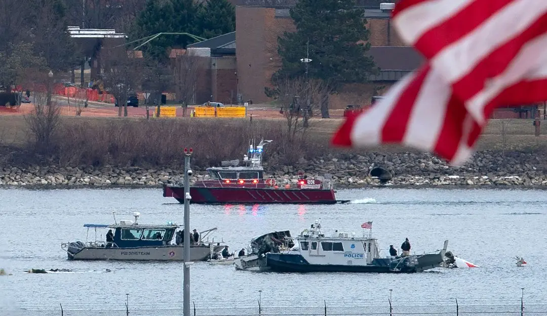A diving team and police boat is seen around a wreckage site in the Potomac River from Ronald Reagan Washington National Airport | Photo: AP