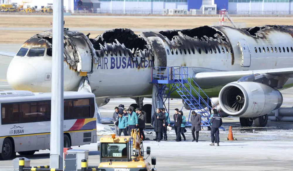 Officials visit the site where an Air Busan airplane caught fire at Gimhae International Airport in Busan | AP