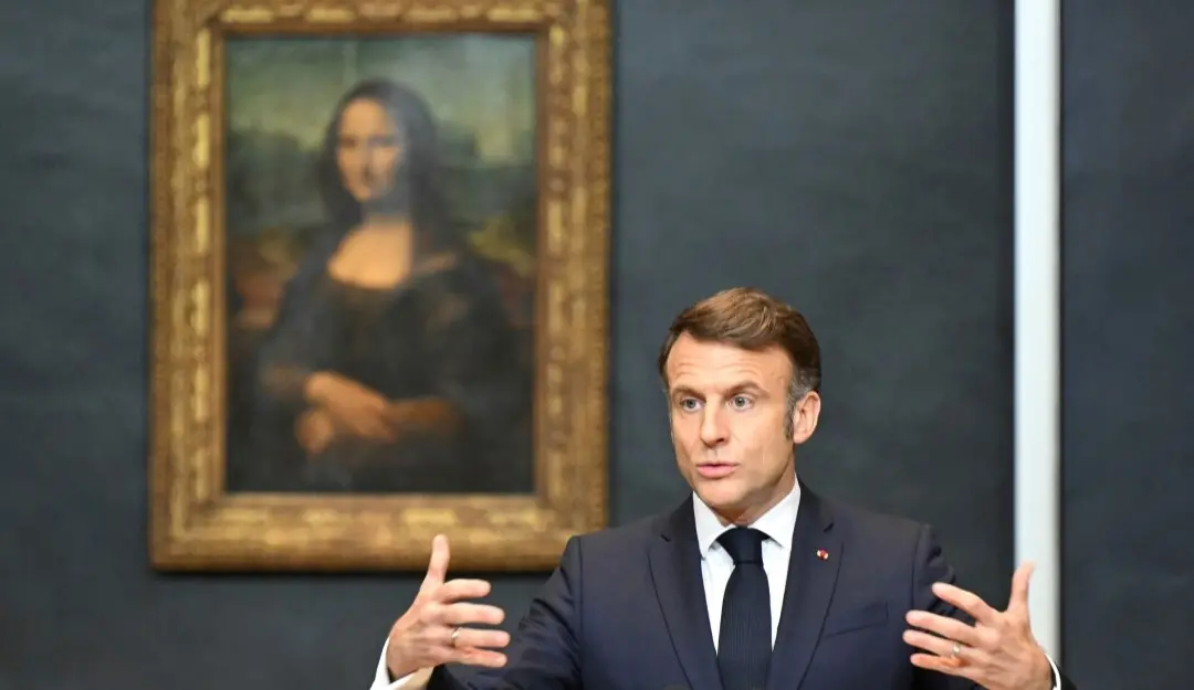 French President Emmanuel Macron gives a speech to announce a multi-year overhaul, long-term investments to modernize the Louvre museum, next to Leonardo da Vinci's painting of the Mona Lisa, at the Louvre Museum