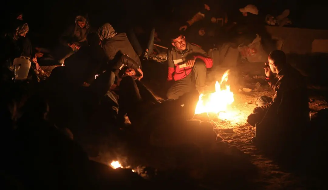 Displaced Palestinians warm themselves by a fire as they wait to return to their homes in the northern part of the Gaza Strip | Photo: AP