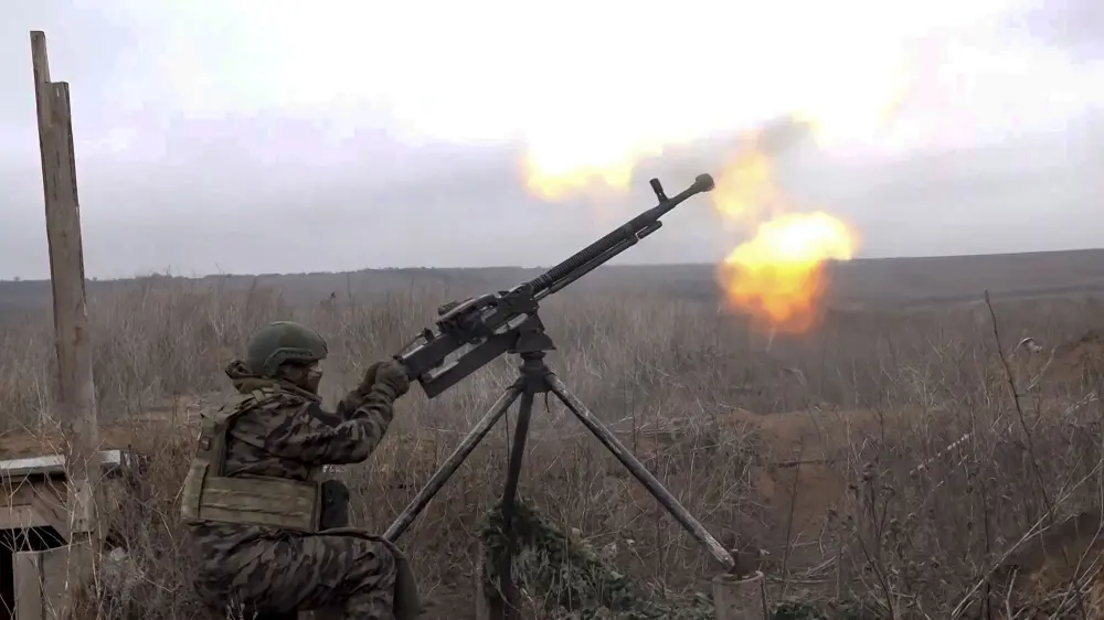 A Russian soldier tries to shoot a Ukrainian drone on an undisclosed location in Ukraine | AP