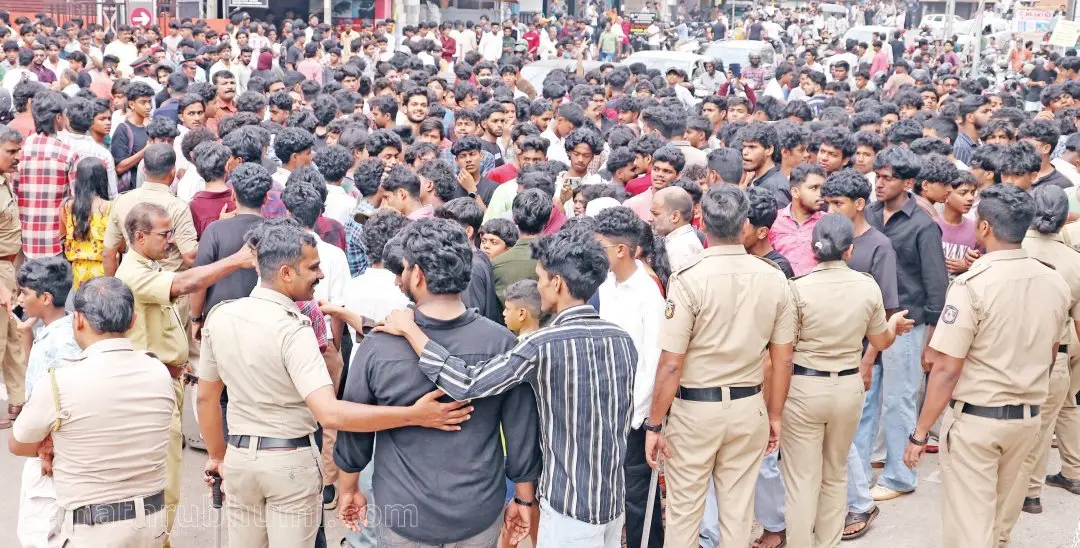 Police trying to disperse the crowd that went frenzy over a special offer for shoes in a Kannur store