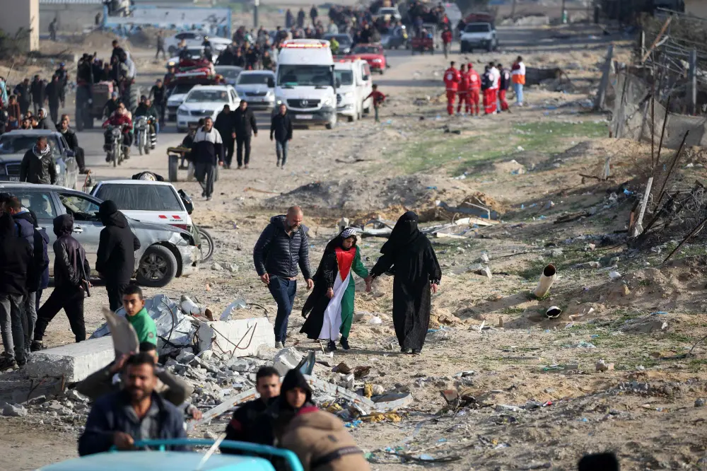 A young woman wears a dress in the colours of the Palestinian flag as people return to Rafah in the southern Gaza Strip | AFP