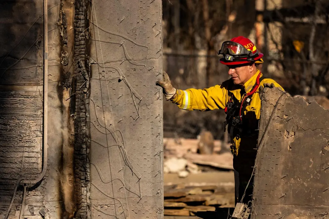 A firefighter walks among the remains of a house reduced to rubble by the Eaton Fire during search and rescue operations in Altadena, California | Photo: AFP