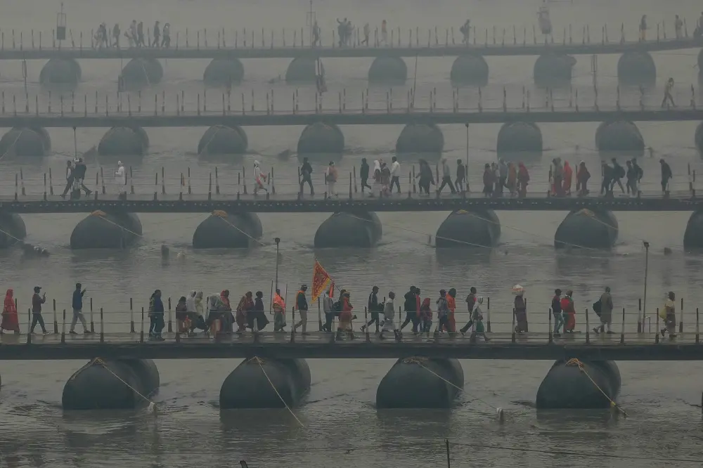 Pilgrims carrying their belongings walk over floating pontoon bridges to go to Sangam, the confluence of the Ganges, Yamuna and mythical Saraswati rivers | AFP