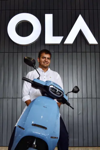 Co-founder and CEO of Ola, Bhavish Aggarwal with the Ola electric scooter. | File image: AFP