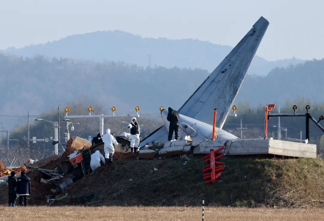 Officials take part in an investigation at the site where a Jeju Air Boeing 737-800 aircraft crashed and burst into flames at Muan International Airport in Muan | Photo: AFP