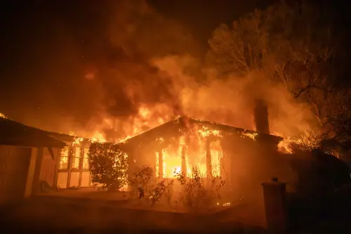 Flames from the Palisades Fire burns a home during a powerful windstorm on January 8, 2025. | AP