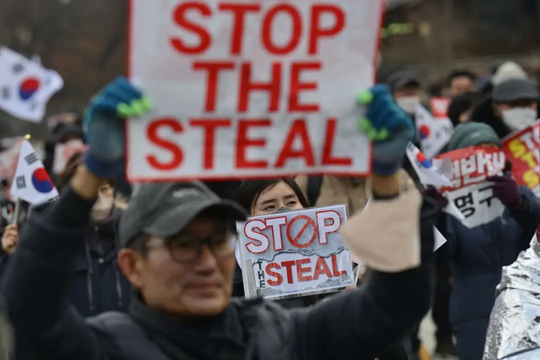 Supporters of impeached South Korea president Yoon Suk Yeol hold 'Stop the steal' signs during a rally near his residence in Seoul on Monday | Photo: AFP
