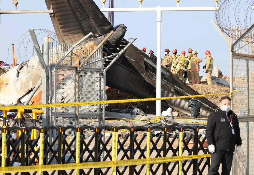 Teams work at the site of the Jeju Air Boeing 737-800 aircraft which crashed and burst into flames at Muan International Airport in Muan | Photo: AFP