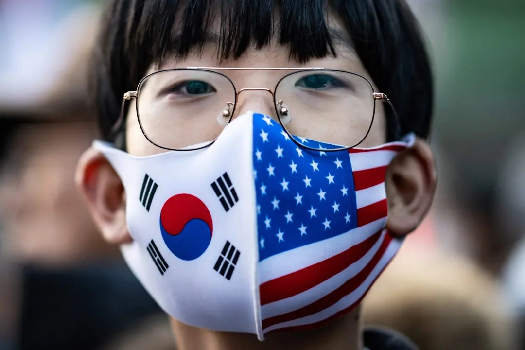 A participant wearing a face mask with US and South Korean flags takes part in a rally to support impeached South Korea's President Yoon Suk Yeol near the presidential residence in Seoul | Photo: AFP