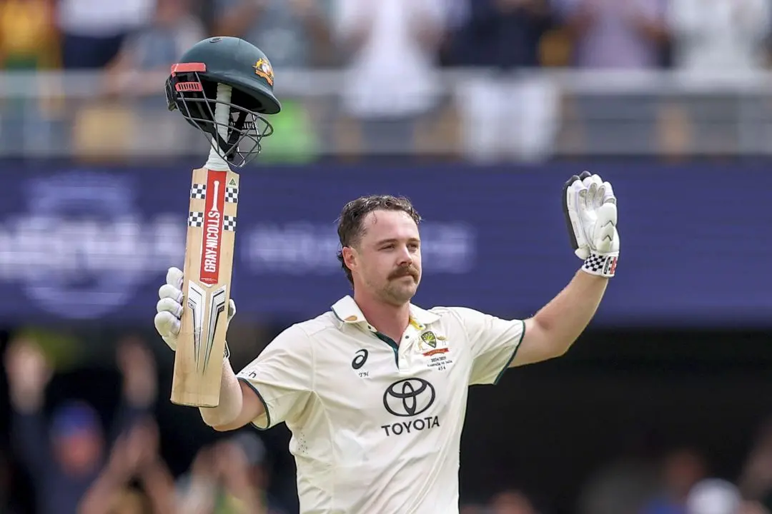 Australia's Travis Head celebrates after scoring a century during play on day two of the third cricket test between India and Australia at the Gabba in Brisbane, Australia