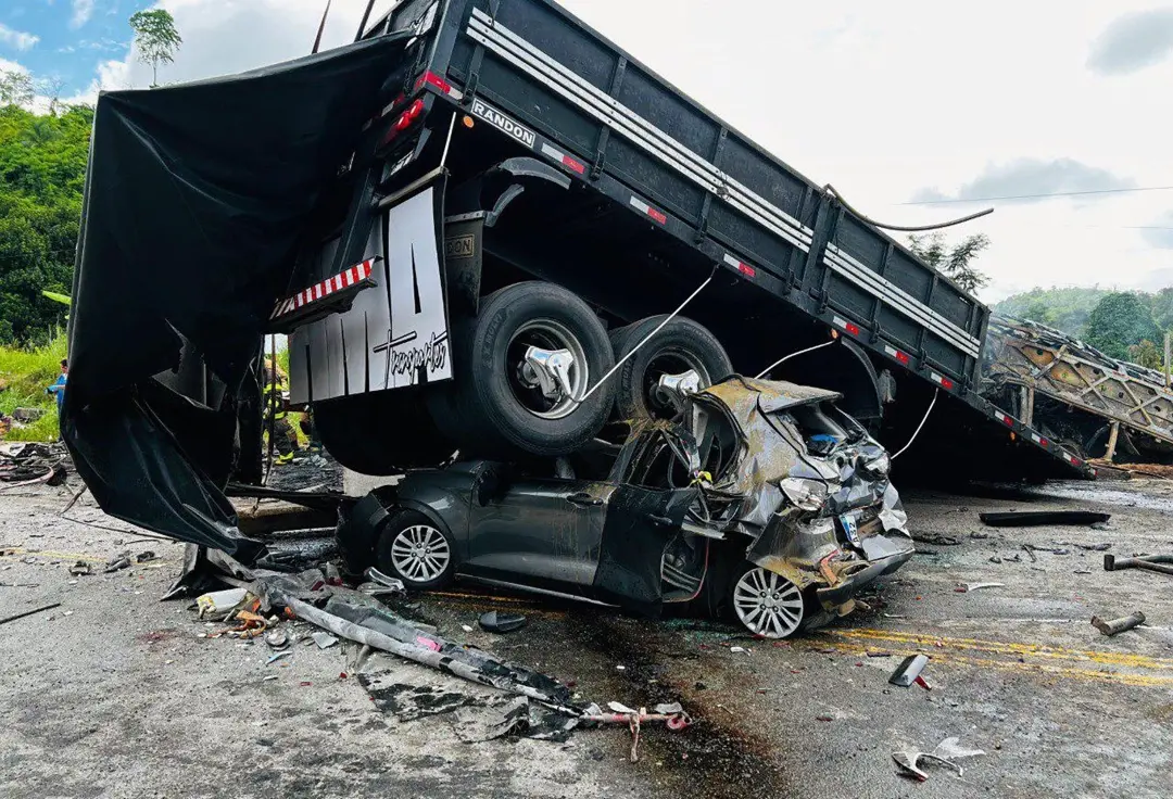 Picture released by Minas Gerais Fire Department shows a truck on top of a car on the site of a crash in Teofilo Otoni, Minas Gerais state, Brazil on Saturday | Photo: AFP