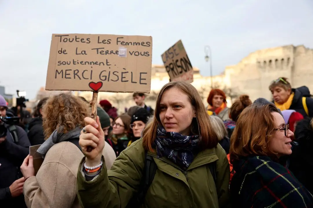 A woman holds a placard reading in French 'all women on earth support you, thank you Gisele' as people gathered outside the courthouse in Avignon on December 19, 2024, awaiting the verdict in the trial of a man, with 50 others, accused of drugging his wife and orchestrating multiple rapes over nearly a decade.
