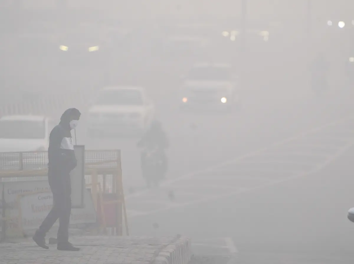 A man crosses a road amid dense fog in New Delhi | Photo: PTI
