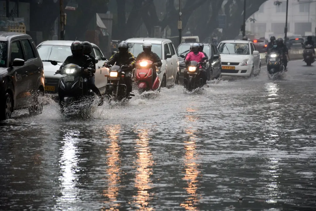Commuters wade through a waterlogged road after rainfall, in Chennai on Thursday | Photo: ANI