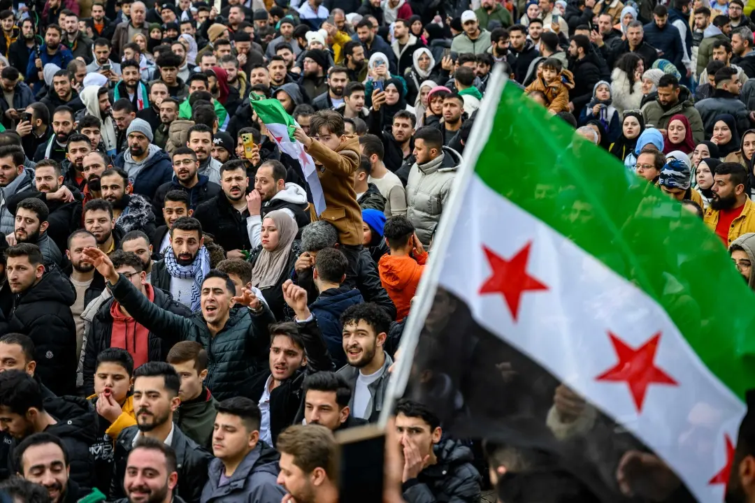 Syrian residents in Turkey wave Syrian flags as they celebrate the end of the Baath rule in Syria after rebel fighters took control of Damascus overnight, at the Fatih Mosque, in Istanbul, on Sunday, December 8, 2024.