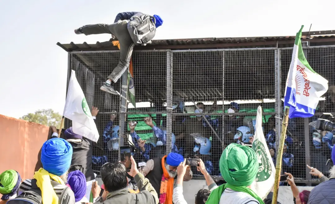 A farmer climbs atop the barricade at Shambhu border after famers commenced their foot march to Delhi, in Patiala district, Punjab | Photo: PTI