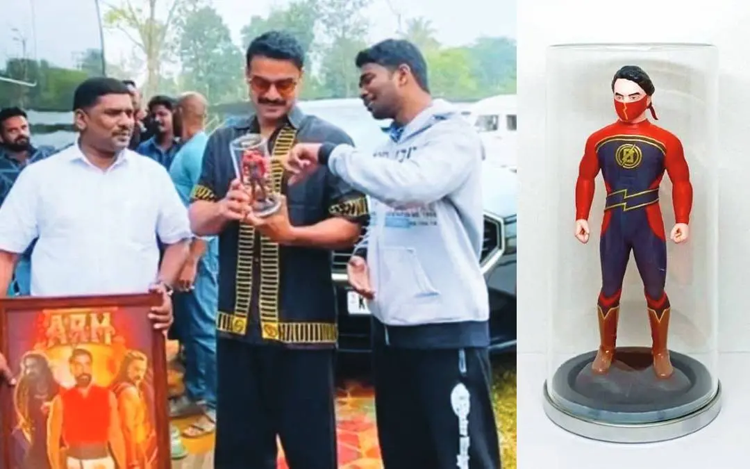 Arun hands over a miniature and framed poster to Tovino, with the miniature of 'Minnal Murali' made by Arun