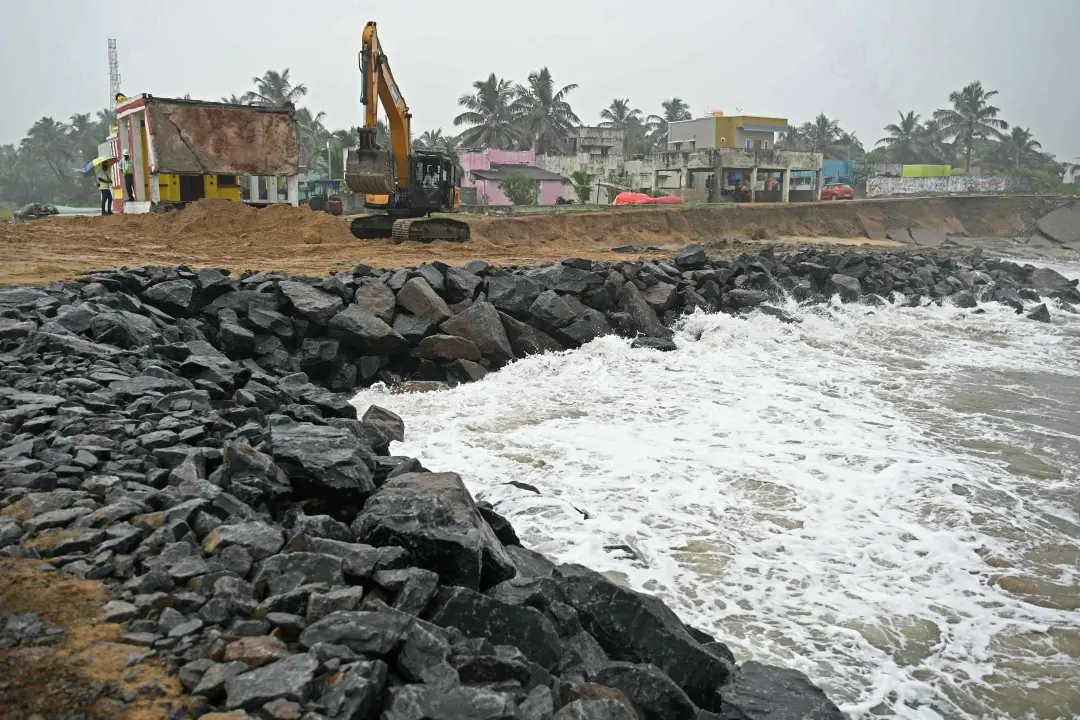 An excavator places stones to curb sea erosion at a coastal village near Mahabalipuram on the outskirts of Chennai on Monday | Photo: AFP