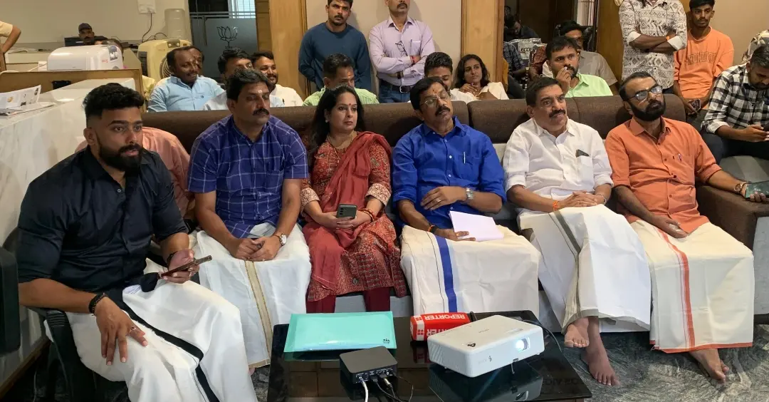 NDA candidate C Krishnakumar (fourth from Left) watching live updates of vote counting along with others in Palakkad on Saturday