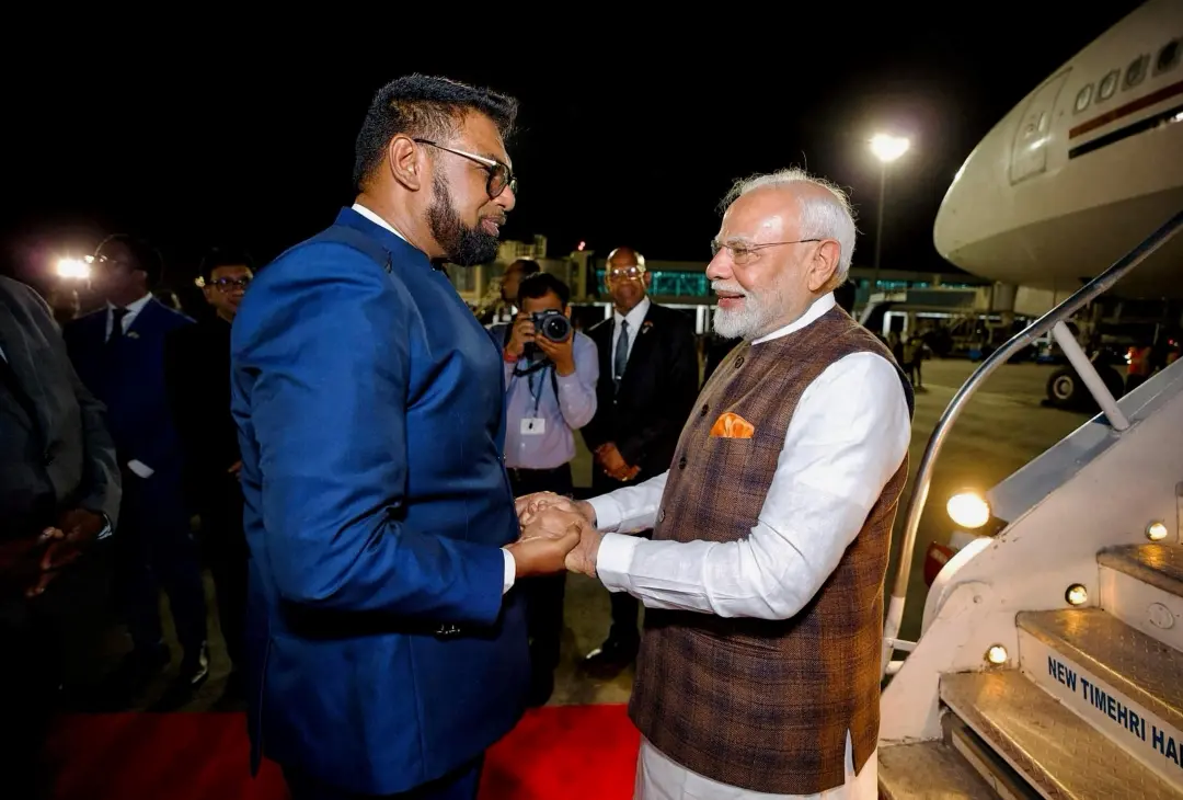 India's Prime Minister Narendra Modi (R) is welcomed by Guyana's President Irfaan Ali
