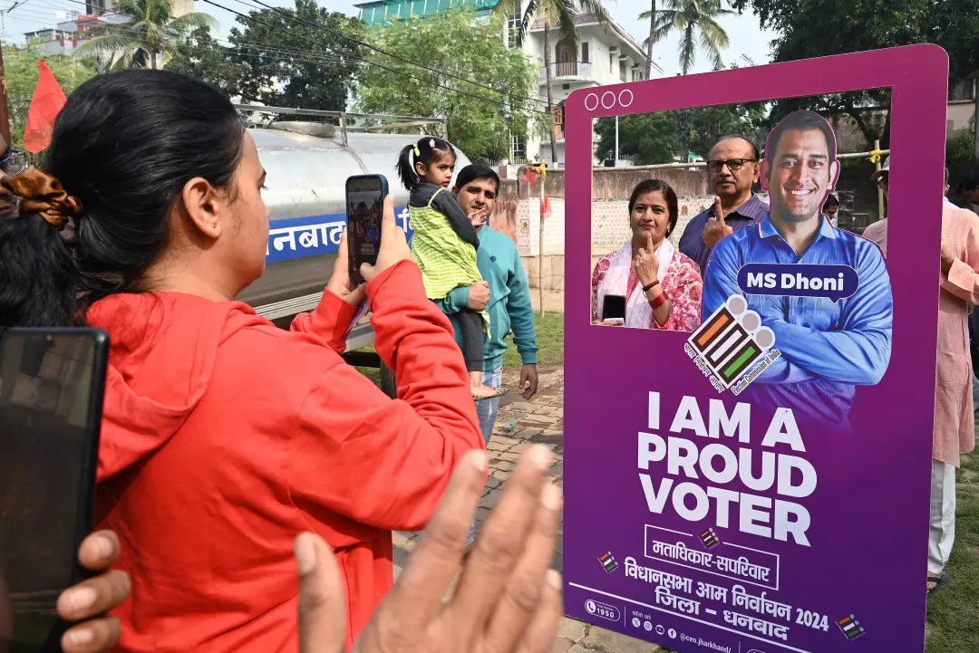 Voters pose for a photo at a selfie booth after casting their votes