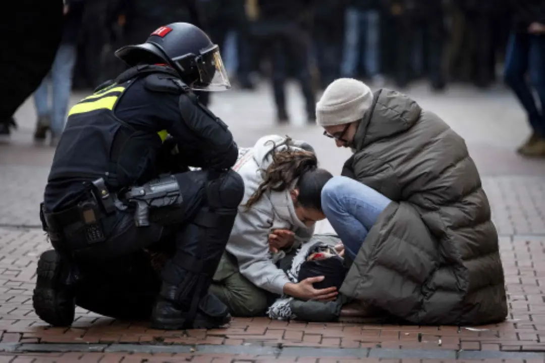 A police officer stands next to demonstrators helping a bloodied pro-Palestinian protester near Dam Square during a Pro-Palestinian protest in Amsterdam. The protest is taking place while an emergency ordinance and demonstration ban are in place in the city. These were previously deployed following tensions and violence surrounding supporters of Israeli football club Maccabi Tel Aviv. | Photo: AFP and other agencies