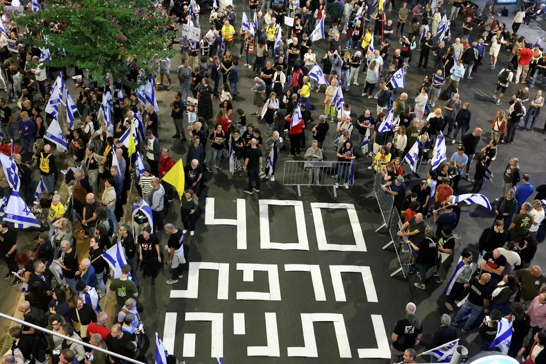 A sign reading in Hebrew, '400 days disgrace Netanyahu' is displayed on the pavement during a rally in Tel Aviv | Photo: AFP